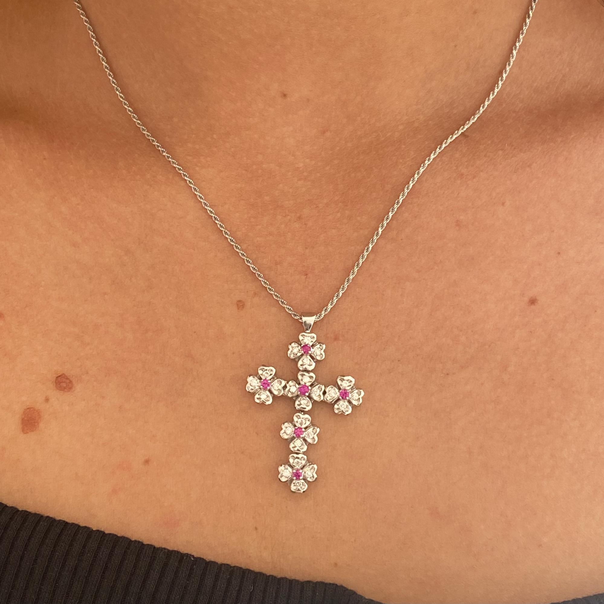 18kt gold necklace with a cross featuring six four-leaf clovers, rubies approx. 0.06 ct, and diamonds approx. 0.25 ct.